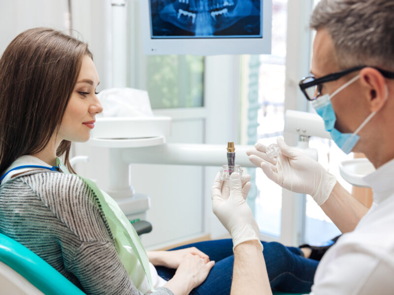 dentist explaining how a dental implant works to patient